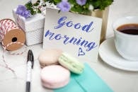 pexels-photo-2072152-2072152 Good morning card with coffee, macarons, and gifts creating a cozy scene.
